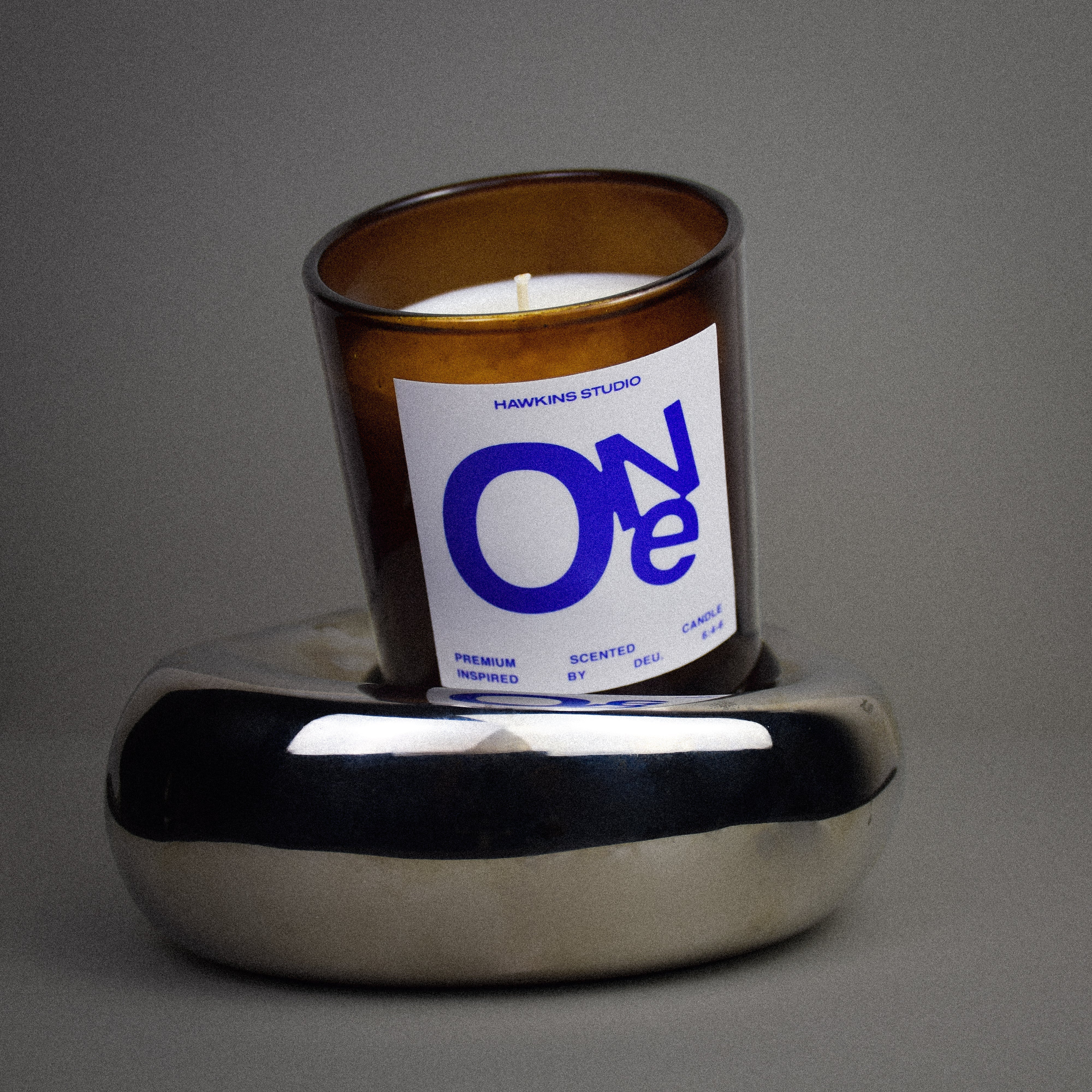 Candle in a glass jar with a label on a gray background